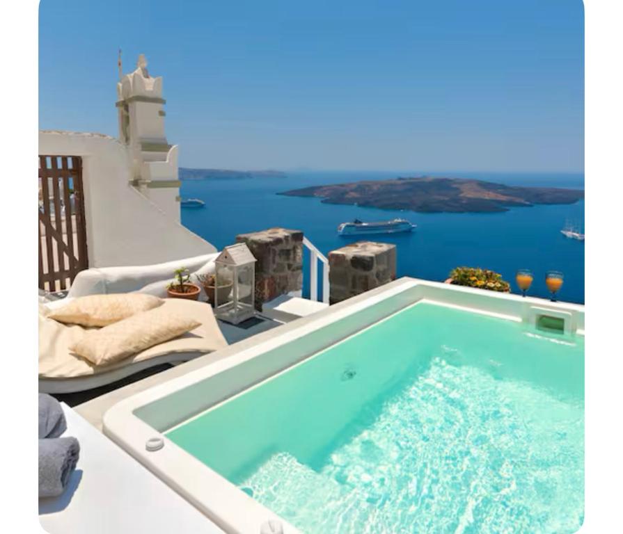 Hot tub on a whitewashed terrace overlooking the caldera at Fira White Residence, Santorini