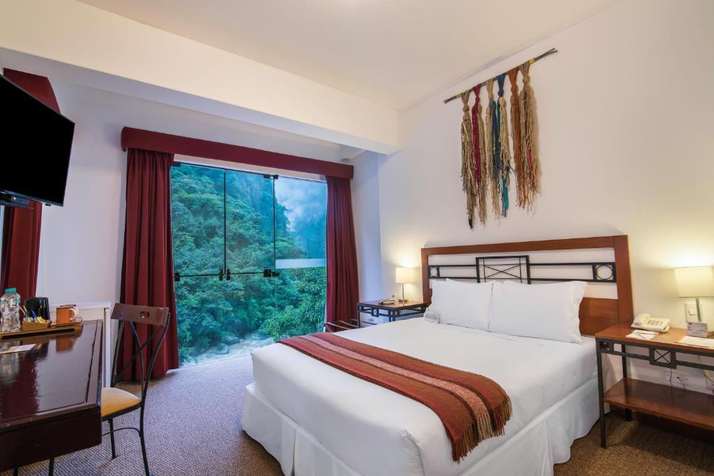 Tierra Viva Machu Picchu hotel room with bed and large window overlooking the mountains in Aguas Calientes, Peru